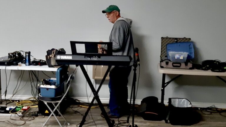 Gerry is setting up the microphones, sound system and equipment to power this weekend's live music at the Dyment Recreation Hall.