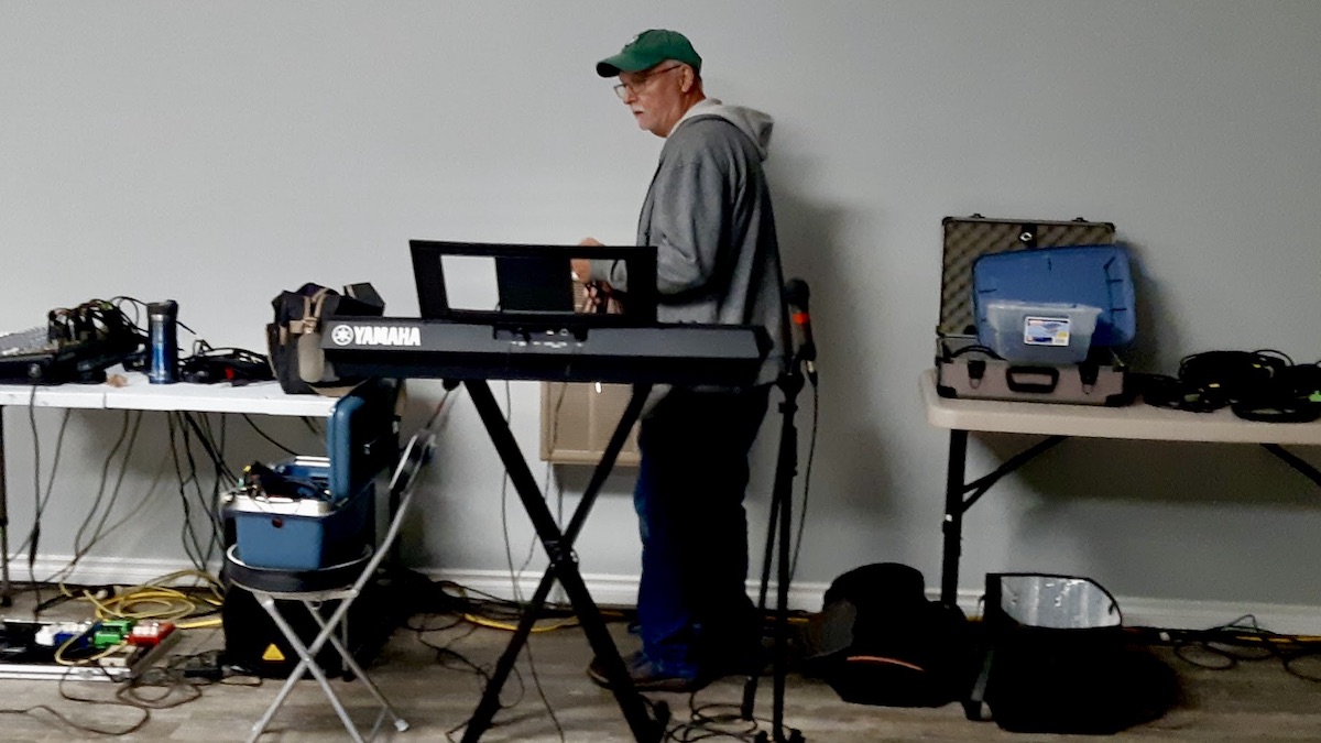 Gerry is setting up the microphones, sound system and equipment to power this weekend's live music at the Dyment Recreation Hall.