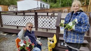 Terri Bell and Karen Daignault were among the community volunteers helping beautify Dyment Recreation Hall through flower planting, hanging planters, and community garden improvements.